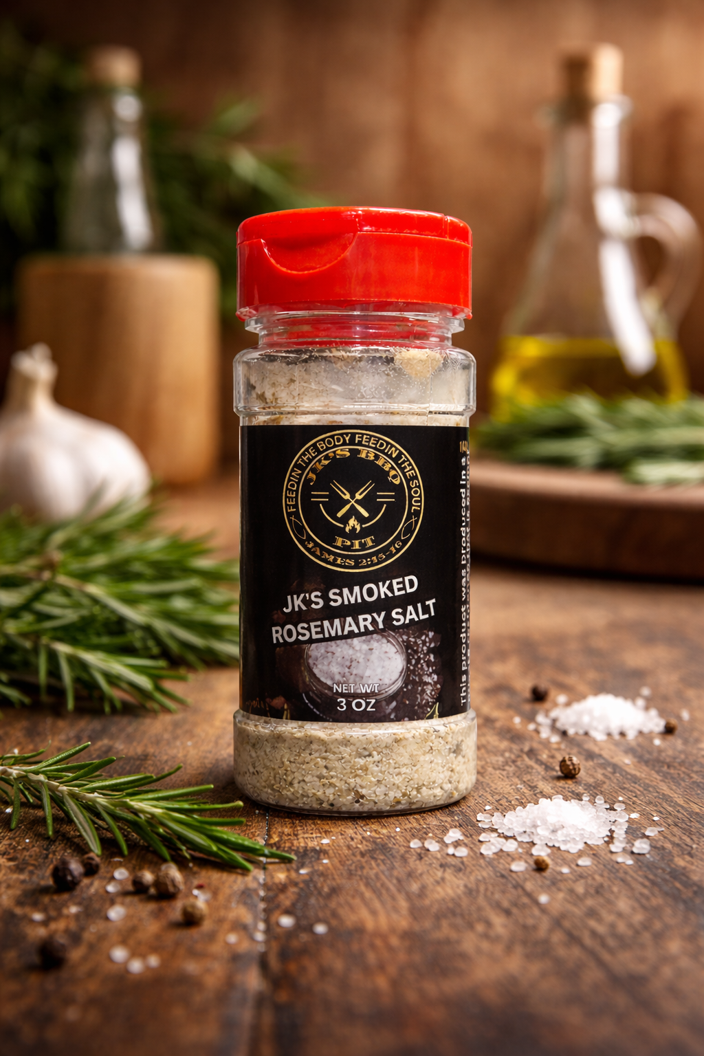 Bottle of smoked rosemary salt on wooden table with fresh rosemary, garlic, and coarse sea salt