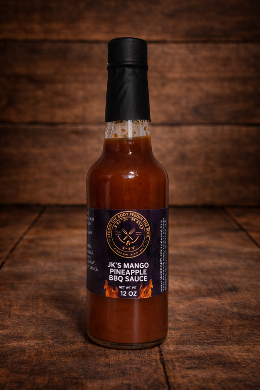 Sweet and smoky JK’s Mango Pineapple BBQ Sauce 12 oz bottle on rustic wooden table background by JK’s BBQ Pit.
