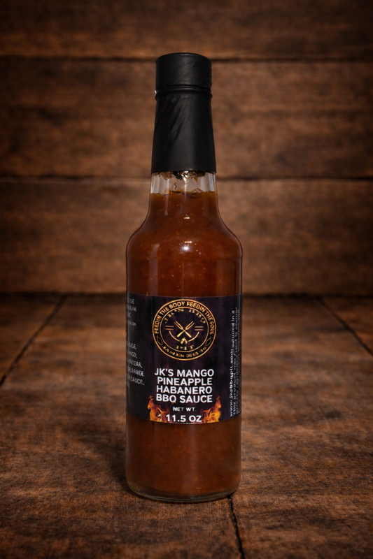 11.5 oz bottle of JK’s Mango Pineapple Habanero BBQ Sauce on rustic wooden background by JK’s BBQ Pit.