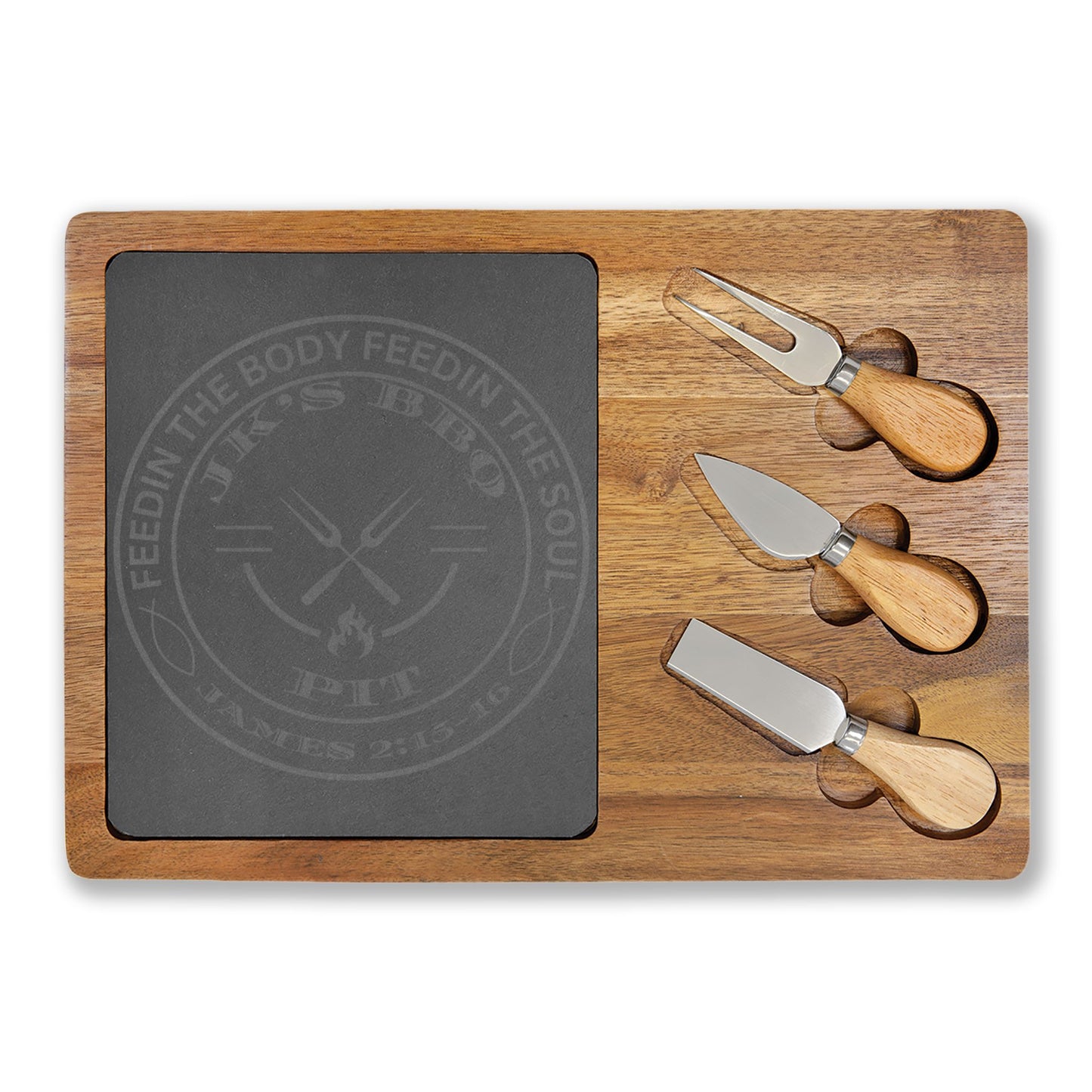 Wooden cutting board with slate surface and three cheese knives on a white background
