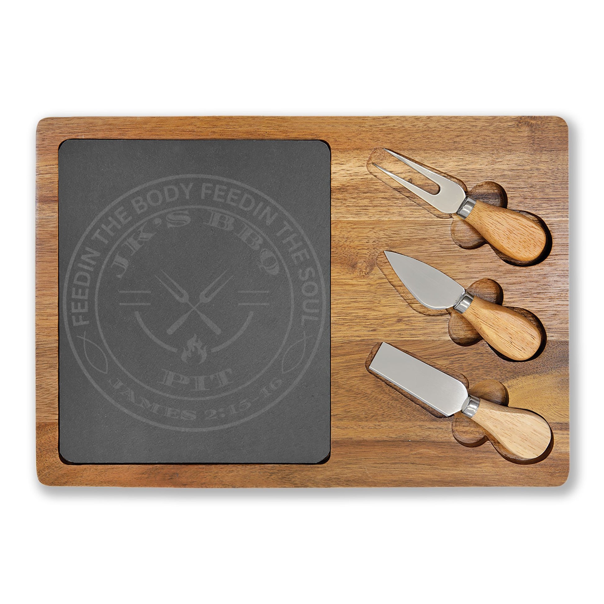 Wooden cutting board with slate surface and three cheese knives on a white background