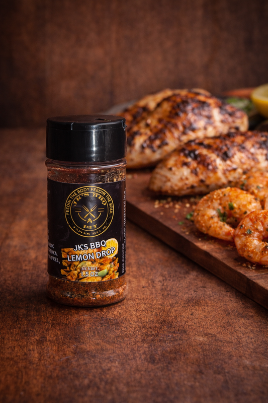 JK's BBQ Lemon Drop seasoning bottle on rustic wood table with grilled shrimp and chicken, citrus BBQ spice blend for seafood and grilled chicken