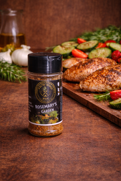 JK's BBQ Pit Rosemary's Garden seasoning bottle on rustic wood table with grilled chicken and vegetables, herb seasoning for poultry and roasted veggies