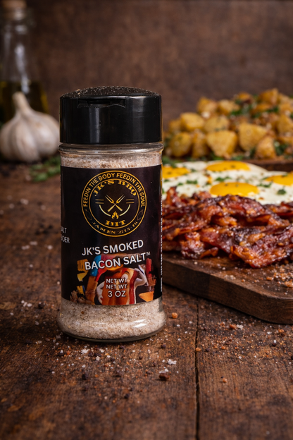 Smoked bacon salt seasoning by JK's BBQ Pit shown with crispy bacon, eggs, and breakfast potatoes on a rustic wooden board.