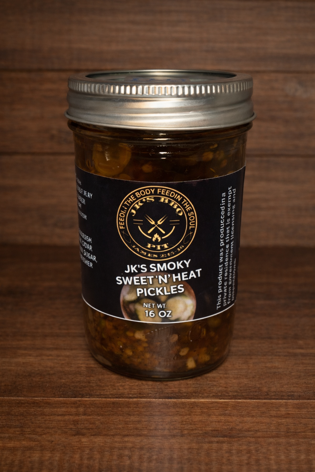 16 oz jar of JK's BBQ Pit Sweet N Heat smoked pickles on rustic wooden background gourmet sweet and spicy pickle slices