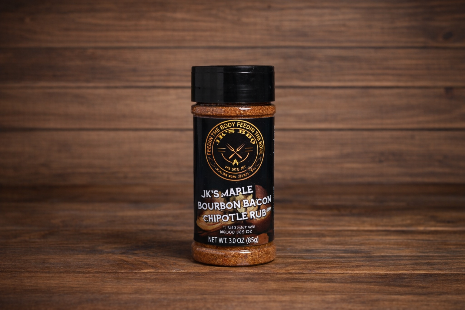JK’s Maple Bourbon Bacon Chipotle rub 3 oz bottle on wooden background, sweet smoky BBQ seasoning for burgers, bacon, and grilling