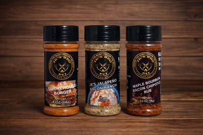 JK’s BBQ Pit Backyard Burger Bundle with Smokehouse Burger, Jalapeño Bacon Ranch, and Maple Bourbon Bacon Chipotle seasonings on a wooden background for grilling and burgers