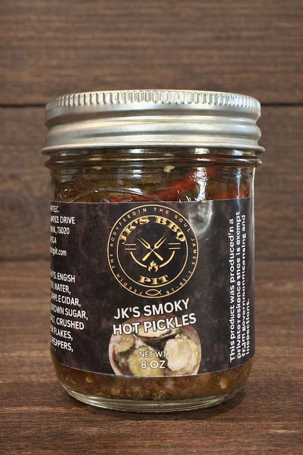 JK's BBQ Pit Smoky Hot Pickles 8 oz jar on rustic wooden background with sliced pickles and red peppers in smoky brine