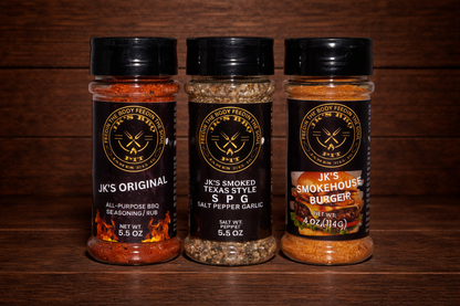 JK's BBQ Starter Bundle featuring Original BBQ Rub, Texas Style SPG, and Smokehouse Burger Seasoning on a rustic wooden table