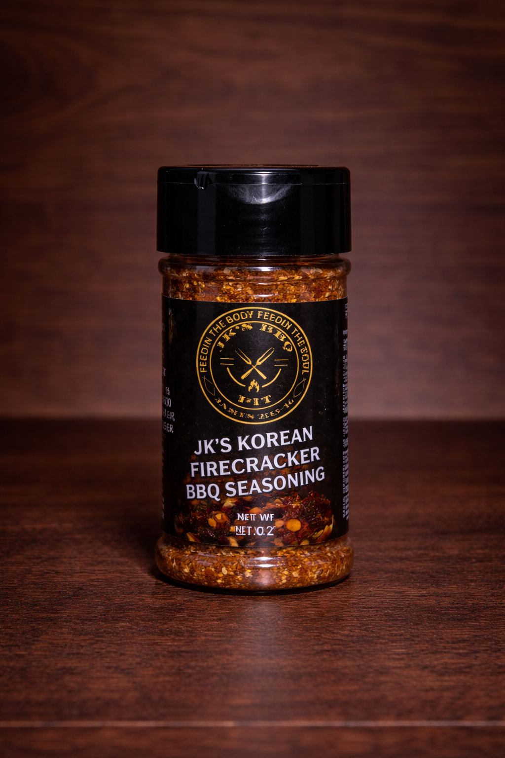 JK’s Korean Firecracker BBQ seasoning 2 oz bottle on wooden background with bold spicy Korean BBQ rub visible in clear jar