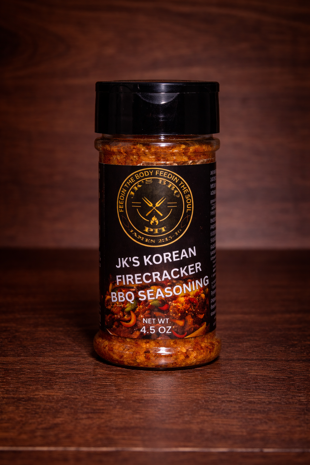 JK’s Korean Firecracker BBQ seasoning 4.5 oz bottle on wooden background with spicy Korean BBQ rub blend visible in clear jar