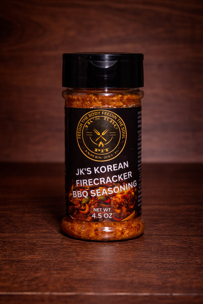 JK’s Korean Firecracker BBQ seasoning 4.5 oz bottle on wooden background with spicy Korean BBQ rub blend visible in clear jar