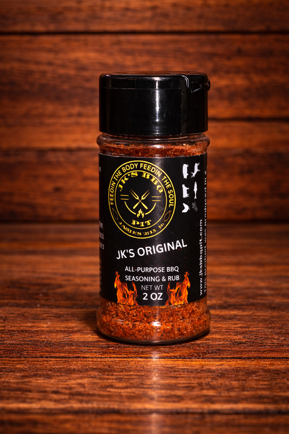 JK's Original All-Purpose BBQ Seasoning Rub 2 oz bottle from JK's BBQ Pit on rustic wooden table and wood wall background