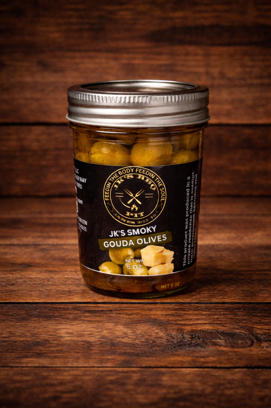 JK’s Smoky Gouda Olives jar on rustic wooden background