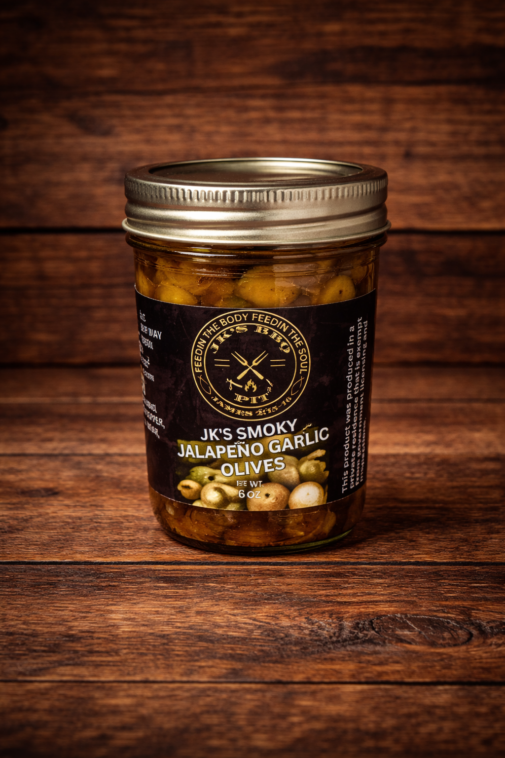 JK’s Smoky Jalapeño Garlic Olives jar on rustic wooden background