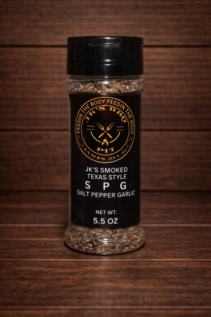 JK's Smoked Texas Style SPG seasoning (salt pepper garlic) 5.5 oz bottle on dark rustic wooden table and wood wall background – Texas style BBQ rub for brisket, steak, and grilling