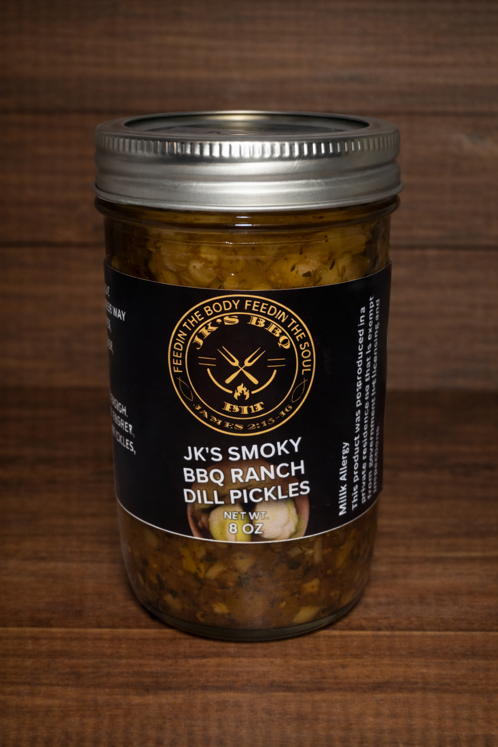 8 oz jar of JK's BBQ Pit BBQ Ranch Dill Pickles on rustic wooden background smoky ranch seasoned pickle slices