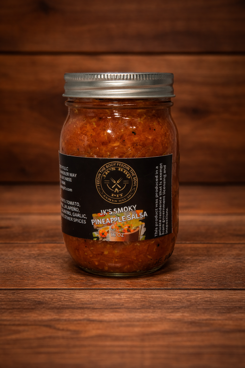 JK’s BBQ Pit Smoky Pineapple Salsa 16 oz jar on rustic wooden background – sweet smoky pineapple salsa perfect for BBQ meats, tacos, nachos, and chips.