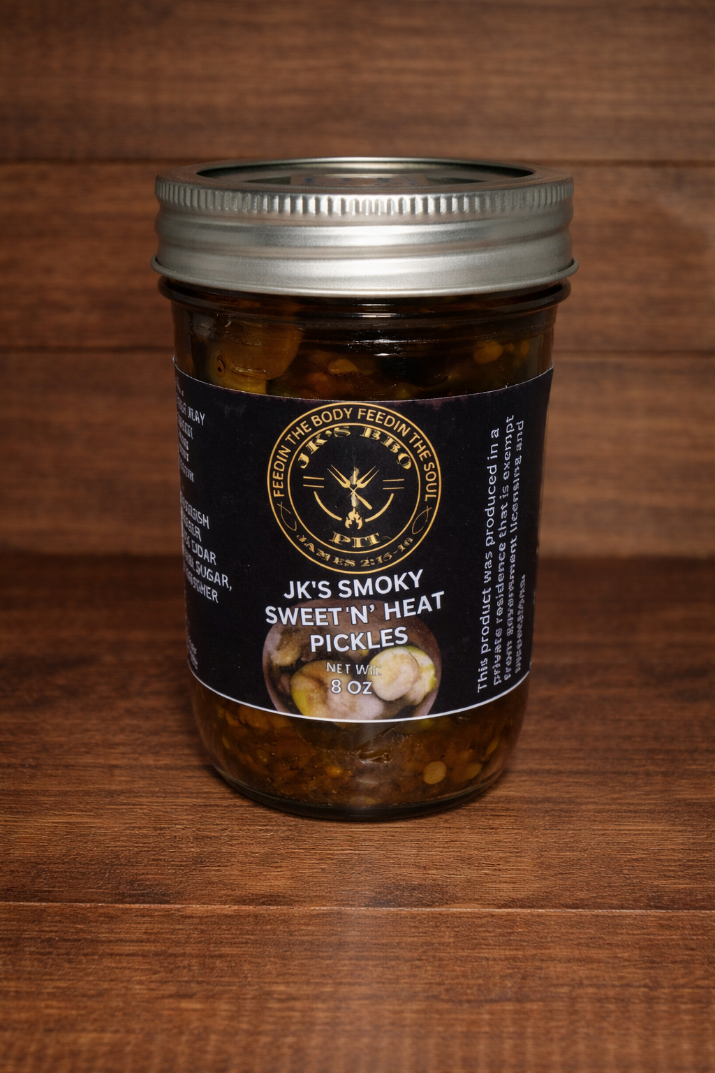 Sweet and spicy smoked pickles by JK's BBQ Pit in 8 oz jar on rustic wood background gourmet pickle snack