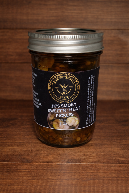 Sweet and spicy smoked pickles by JK's BBQ Pit in 8 oz jar on rustic wood background gourmet pickle snack